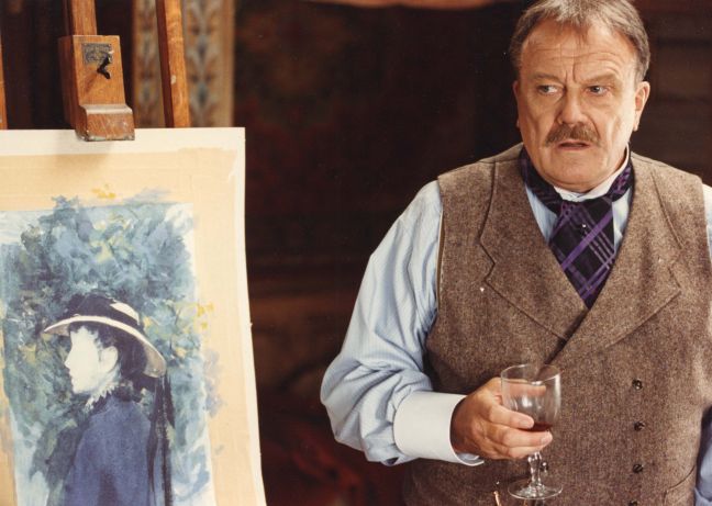 Anders Zorn mit Weinglas neben einem seiner Bilder