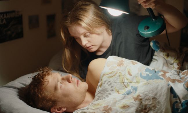 Iiris hält Pauli eine Lampe vor dem Gesicht, Pauli liegt im Bett