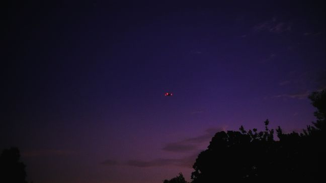 Blinkende Drohne am Abendhimmel