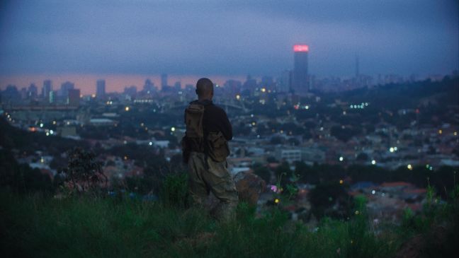 Ein Wachmann schaut von einem Hügel aus über die Stadt