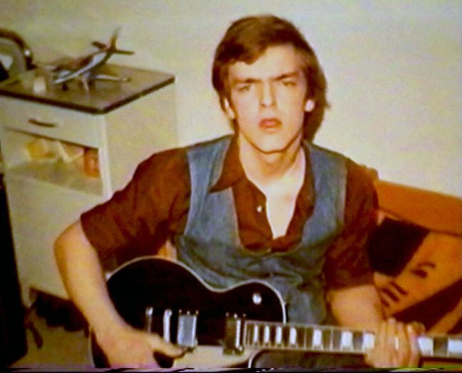 Ein junger Mann mit Gitarre im Arm