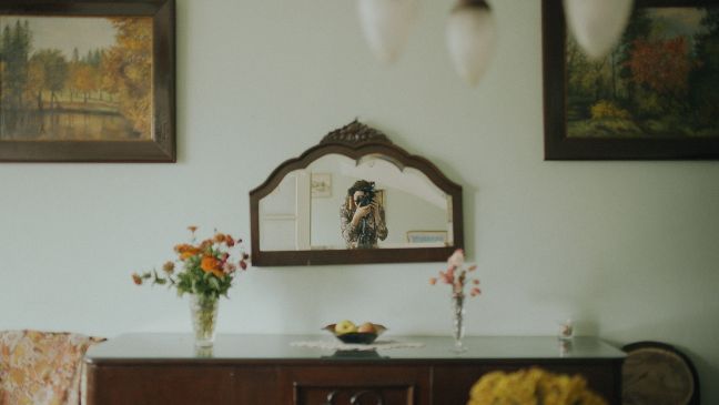 Alexandra fotografiert sich im Spiegel im alten Haus