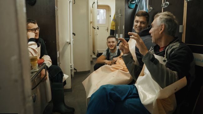 Die Besatzung hört einem Älteren zu