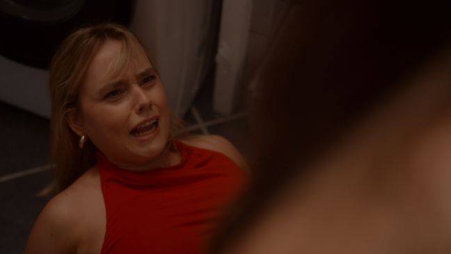 Ein Mädchen liegt auf dem Boden und verzieht das Gesicht