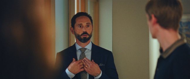 Markus schaut erstaunt und zeigt auf sich, Johannes verschwommener Hinterkopf