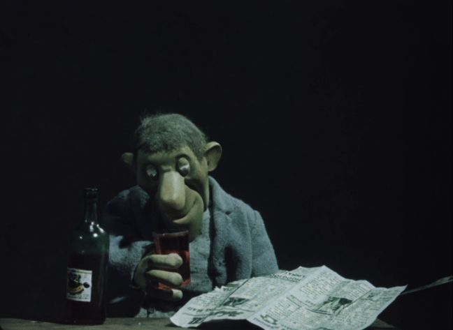 Der Mann schaut in sein Glas voller Alkohol