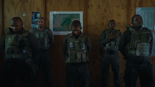 Fünf Securitymitarbeiter mit geschlossenen Augen im Gebet