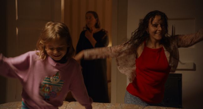 Irina und ihre Tochter tanzen, die Großmutter ist im Hintergrund