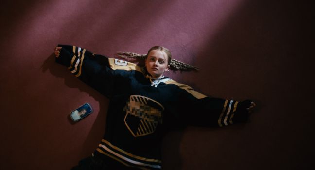 Luca liegt mit ausgestreckten Armen auf dem Boden, das Smartphone daneben