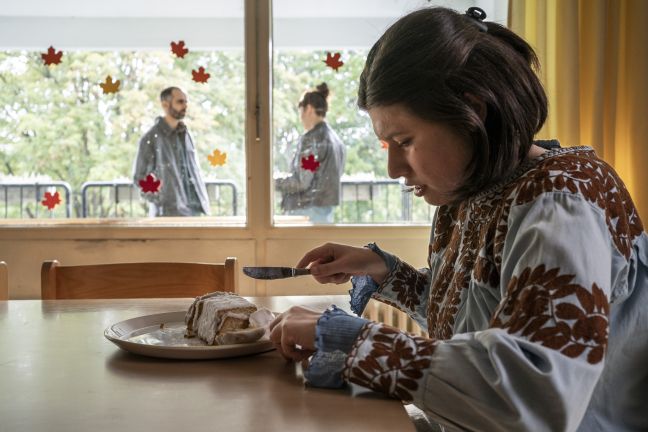 Luisa sitzt am Esstisch und schneidet Kuchen