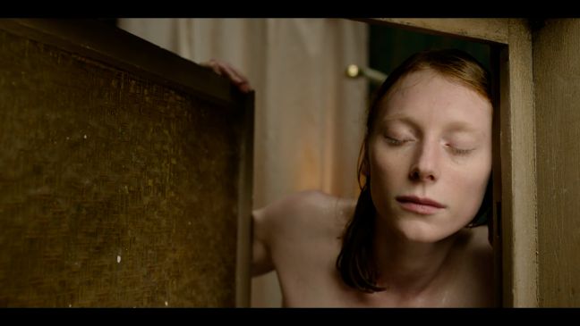 Nore mit nassen Haaren und geschlossenen Augen im Türrahmen