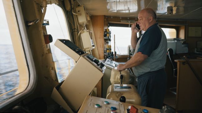Der Kapitän steht auf der Brücke des Trawlers