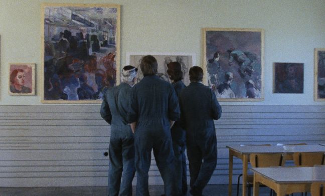 Arbeiter betrachten eine Bilderausstellung