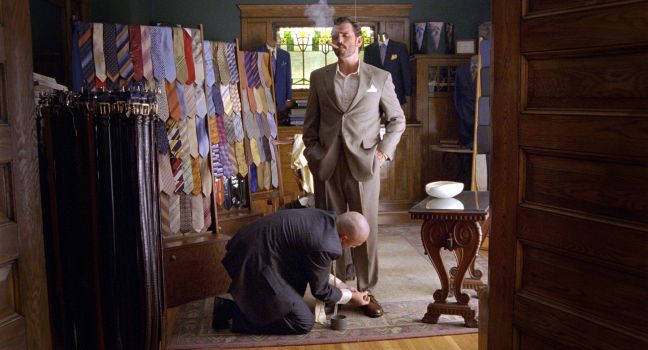 Hank lässt sich beim Herrenausstatter einkleiden und raucht eine Zigarre