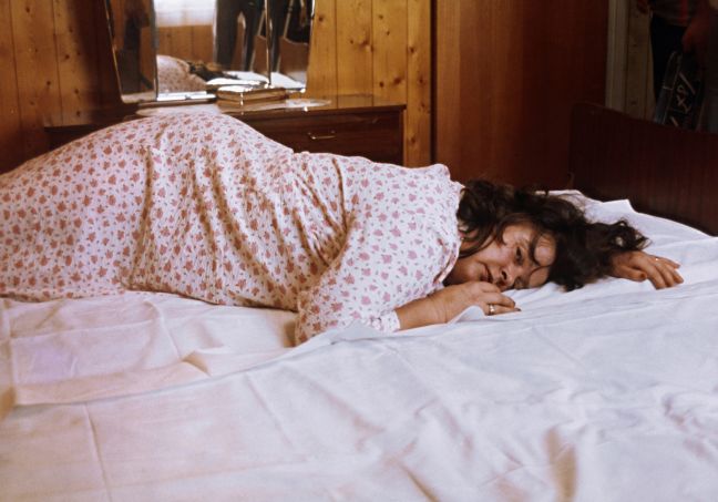 Frau liegt bäuchlings auf dem Bett