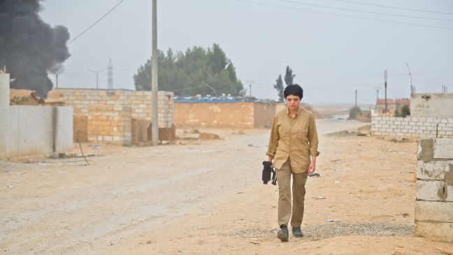Maryam mit Kamera auf einer Straße in Rojava