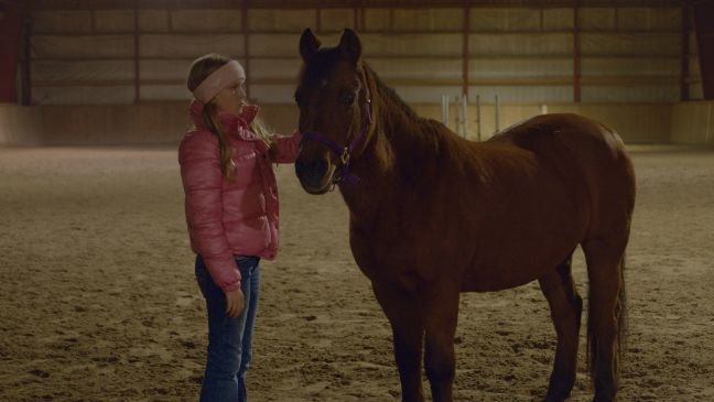 Pia mit einem Pferd im Stall