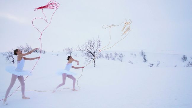 Zwei Ballerinas im Schnee schwingen Seile in der Luft