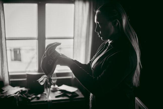 Frau guckt sich eine traditionelle Sámi-Kopfbedeckung an.