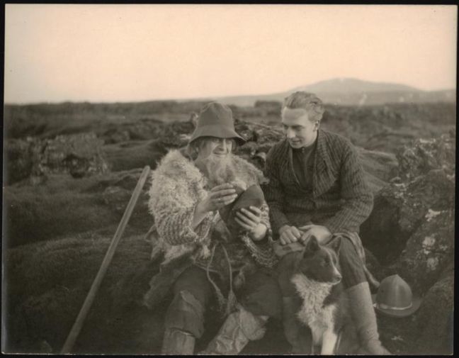 zwei Männer und ein Hund sitzen auf Felsen