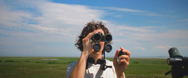 Kilian Helmbrecht guckt durch ein Fernglas