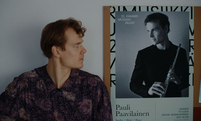 Pauli neben einem Plakat für eines seiner Konzerte