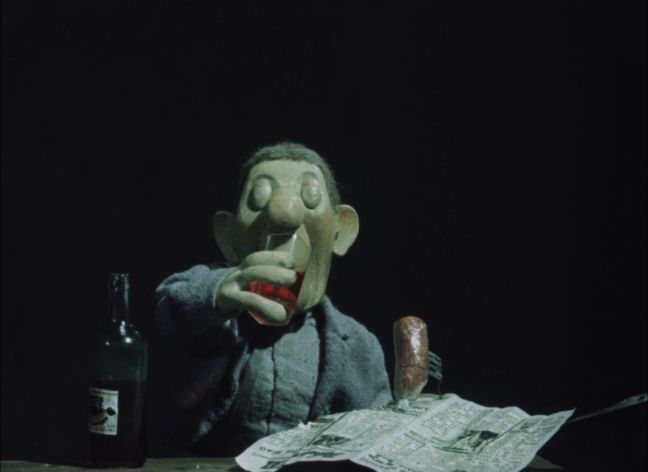 Der Mann trinkt Alkohol und hat eine Wurst in der Hand