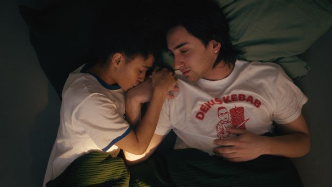 Samir liegt im Bett mit seiner Freundin, sie küsst auf seine Hand