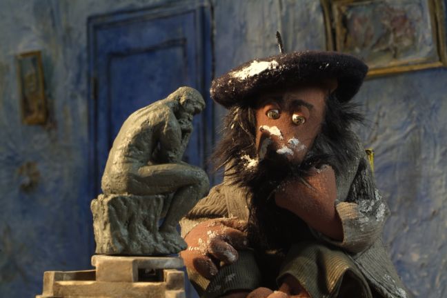 Ein Bär, mit Farbe verschmiert, grübelt neben dem „Denker" von Rodin