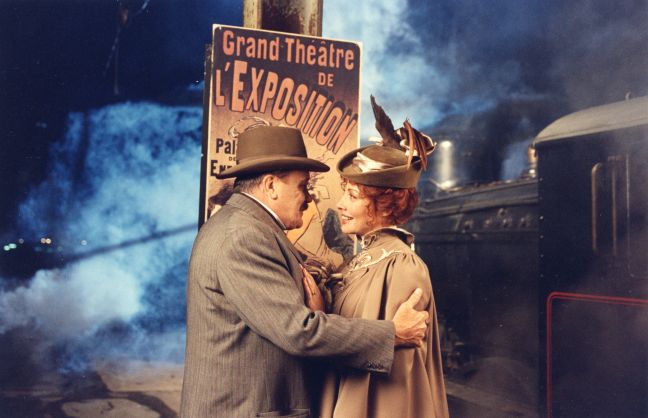 Anders Zorn und Emilie Bartlett umarmen sich vor einem Theaterplakat