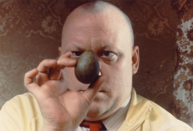 Konrad hält sich ein schwarzes Ei vor das Gesicht