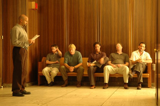 Hank sitzt mit vier weiteren Männern auf einer Bank