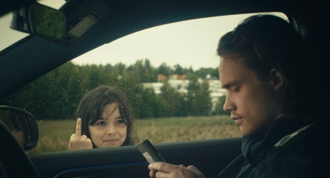 Ninni zeigt am Autofenster den Mittelfinger