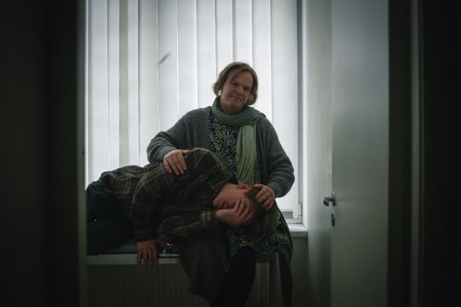 Mann liegt im Berits Schoß und weint