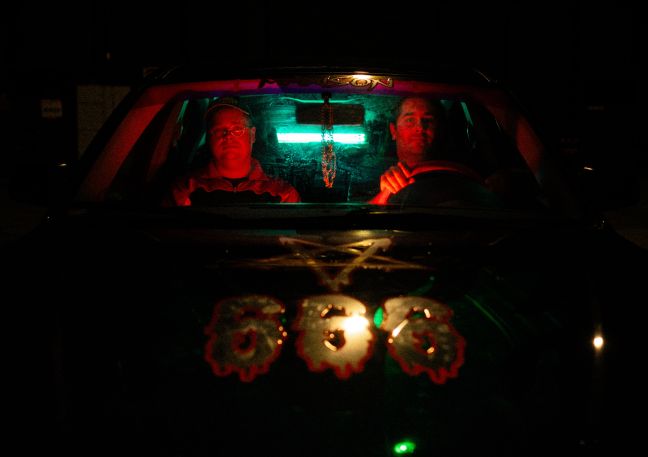 Martin und Casper im Auto im Dunkeln; auf der Motorhaube steht 666