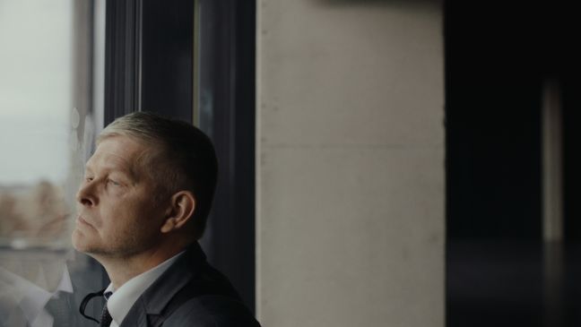 Der Mann presst sein Gesicht gegen eine Scheibe