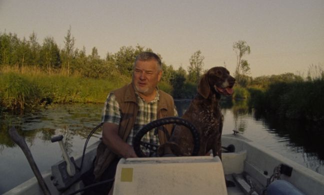 Ein Einheimischer fährt mit seinem Motorboot und Hund auf dem See