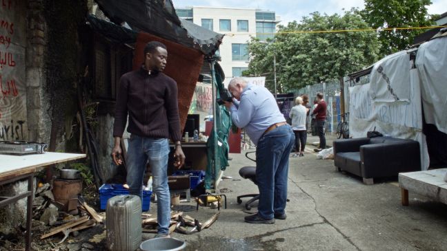 Besucher:innen im Protestcamp, ein Mann fotografiert