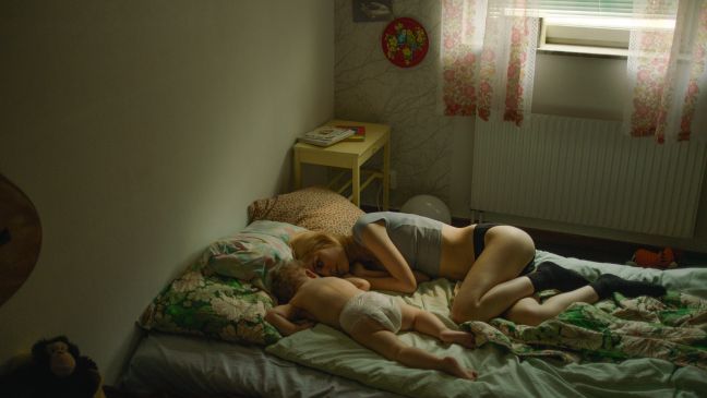 Esther liegt mit ihrem Baby auf einem Einzelbett