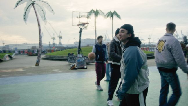 Samir mit einer Gruppe auf dem Basketballplatz, am Lächeln