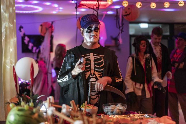 Halloween Feier, am Buffett steht ein Anton als Skelett verkleidet