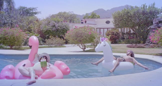 Karla mit Diadem und einer Freundin auf dem Bett, sie lächeln sich an