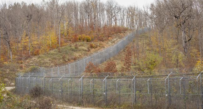 Ein massiver Stacheldrahtzaun durchflügt die Landschaft