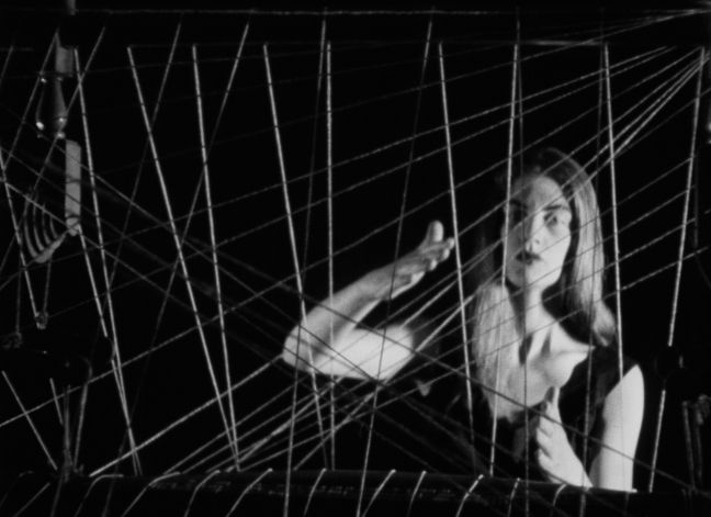 Frau in abstrakter Bewegung mit gespannten Drähten vor sich