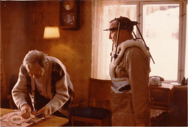 Far hat eine Apparatur um den Kopf, während Moe Karten auslegt