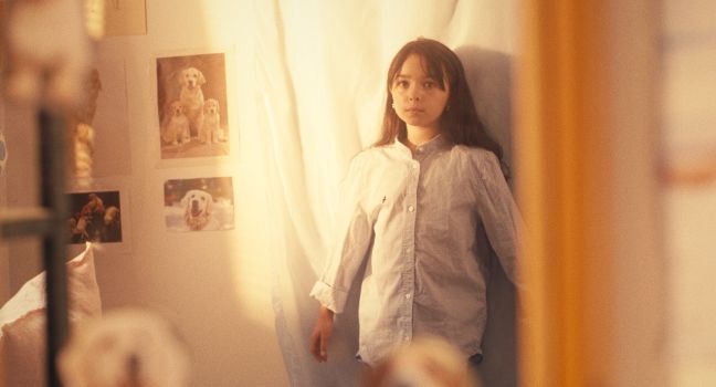 Ninni drückt sich an die Wand im Kinderzimmer