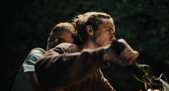 Robin schmiegt sich an Alex nachts auf dem Motorrad