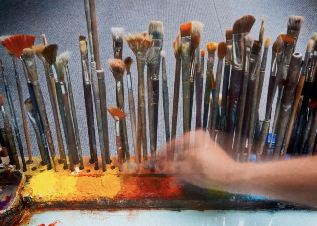 Robert Bosisio Hand, der sich einen Pinsel nimmt