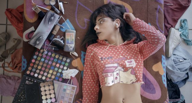 Karla iiegt auf dem Boden und schaut auf ihre Beauty-Produkte