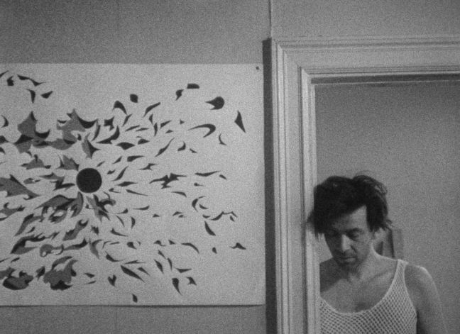 Peter Weiss steht im Türrahmen neben einem Bild